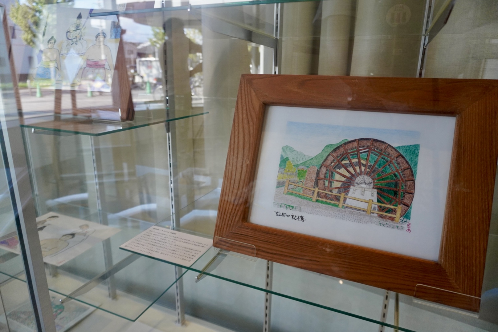 死刑確定者の奥本章寛さんによる色鉛筆の絵画の展示の様子。故郷の風景が描かれている。