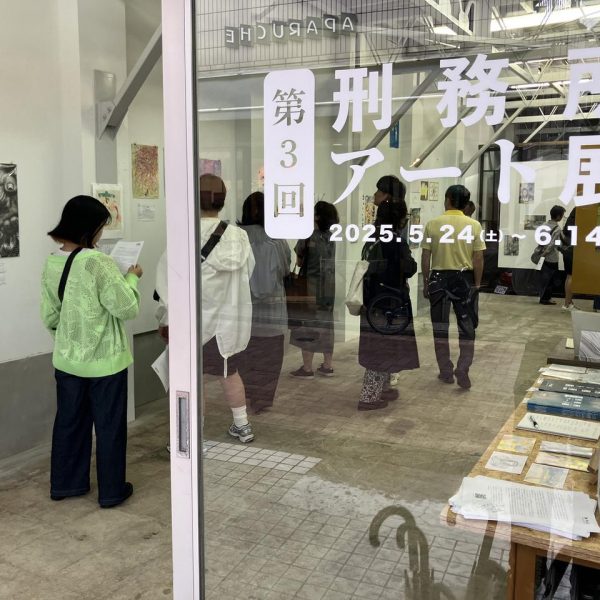 「第3回刑務所アート展」の会場入口で作品を観る来場者たち